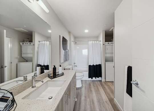 A modern bathroom with a double sink vanity and a walk-in shower.