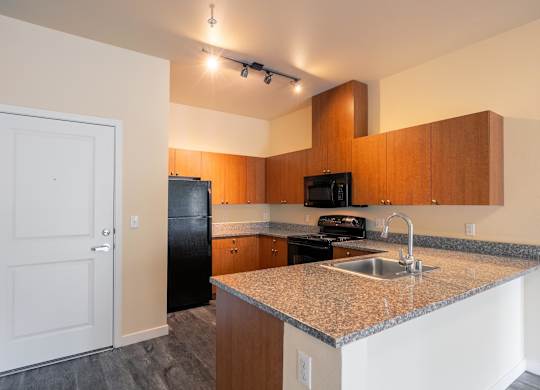 A kitchen with a sink, stove, and refrigerator.