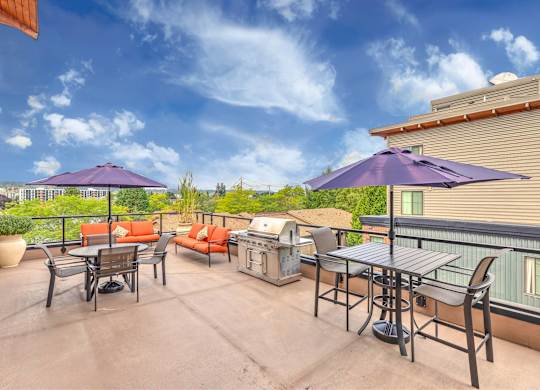 A patio with a table and chairs and umbrellas.
