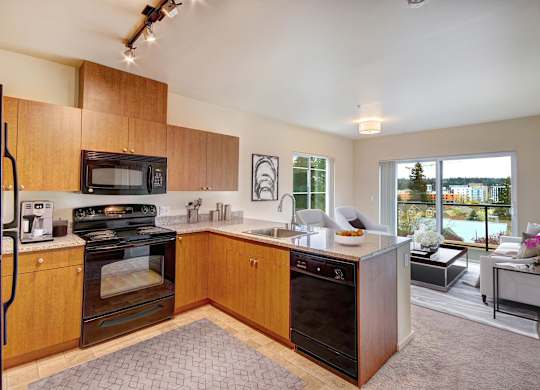 A kitchen with wooden cabinets and a black oven.