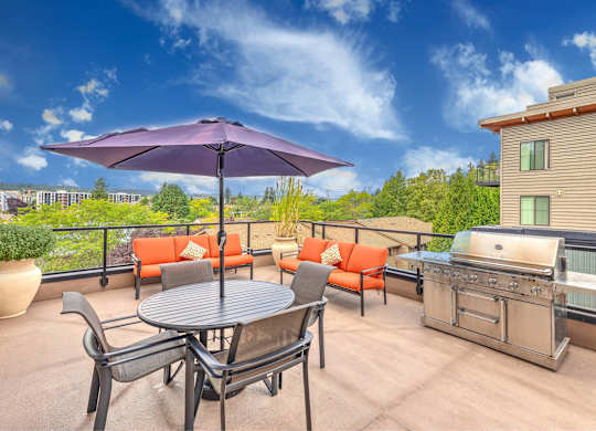 A patio with a table, chairs, and an umbrella.
