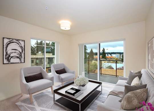 A living room with a grey couch, two chairs and a coffee table.