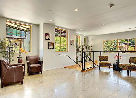 A living room with a staircase and a plant.