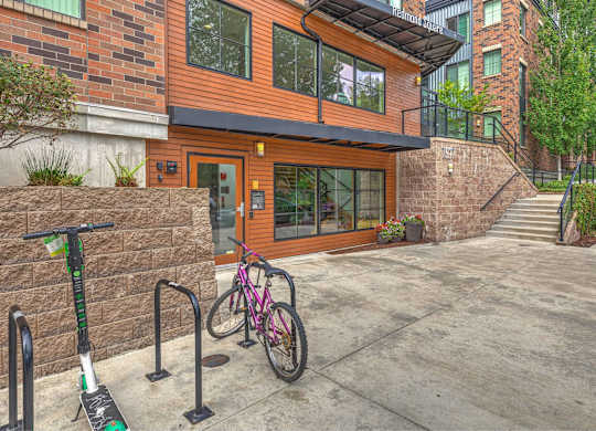 A modern house with a bicycle and a scooter parked in front.