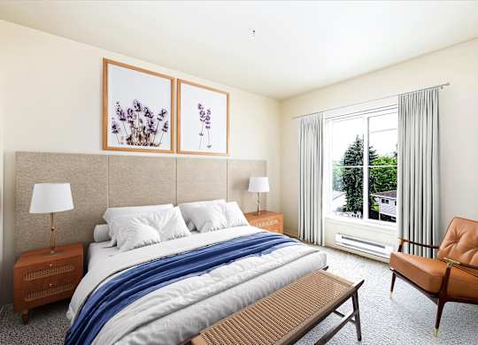 A bedroom with a large bed, a chair, and two framed pictures on the wall.