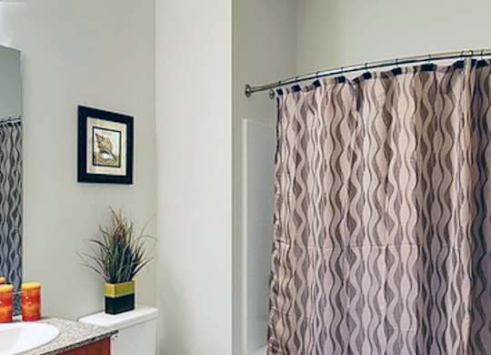 A bathroom with a toilet, sink, and shower curtain.