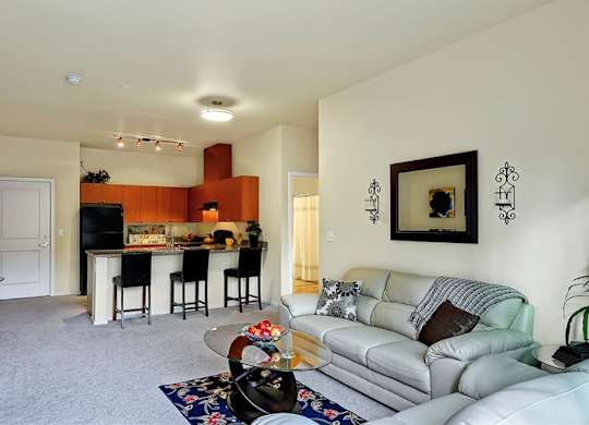 A living room with a white couch and a bar area.
