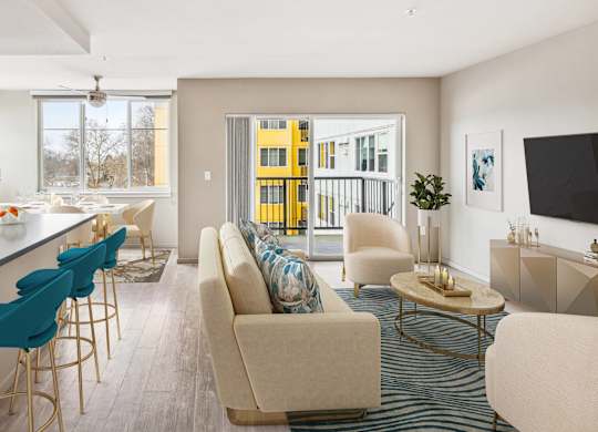 A modern living room with a bar area and a view of a yellow building outside.