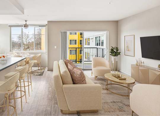 A modern living room with a bar area and a view of a yellow building outside.