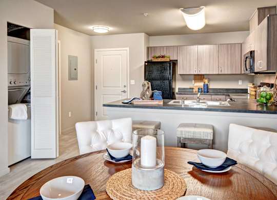 A modern kitchen with a dining table set for two.
