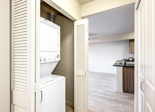A white refrigerator is in a kitchen next to a white door.