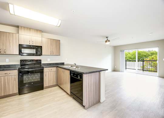 A kitchen with wooden cabinets and black appliances.
