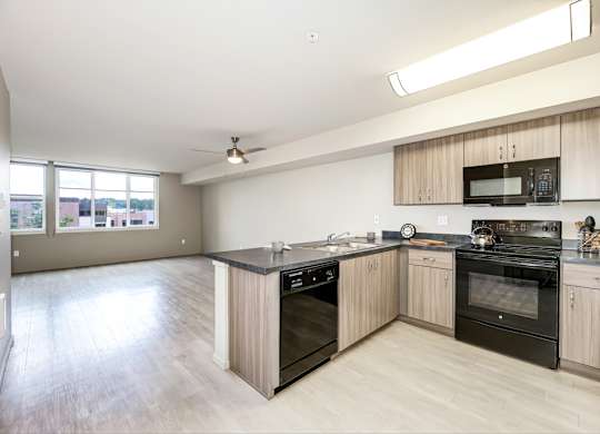 A kitchen with black appliances and wooden cabinets.