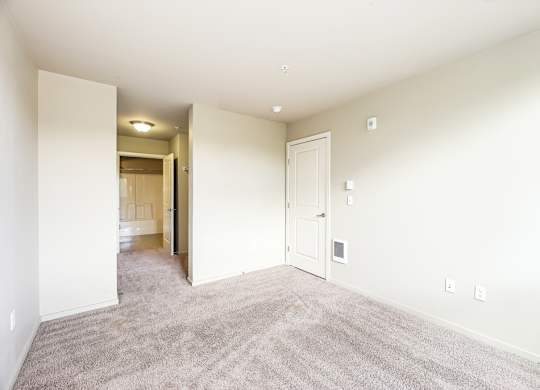 A room with a carpeted floor and white walls.