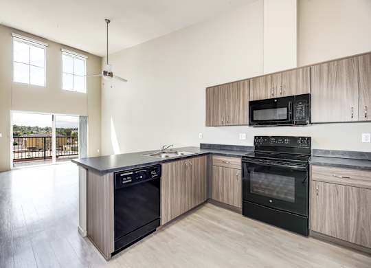 A kitchen with a black oven and wooden cabinets.