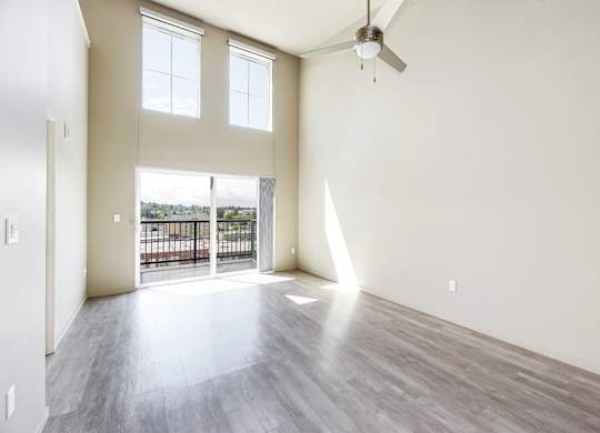 A room with a balcony and a ceiling fan.