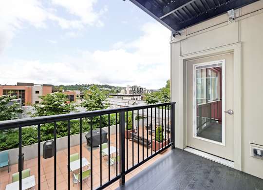 A balcony with a black railing and a white door.