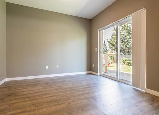 A room with a sliding glass door leading to a backyard.