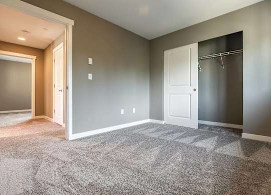 A room with a carpeted floor and a white door.