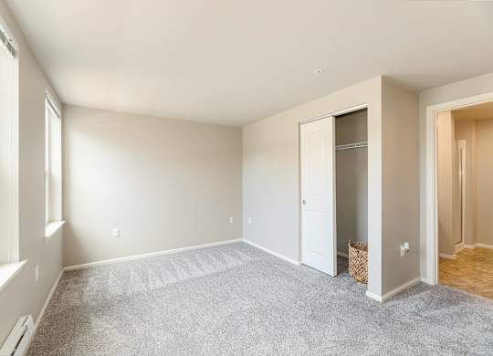 A room with a carpeted floor and a white door.