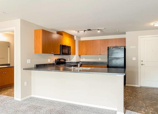 A kitchen with a white island and wooden cabinets.