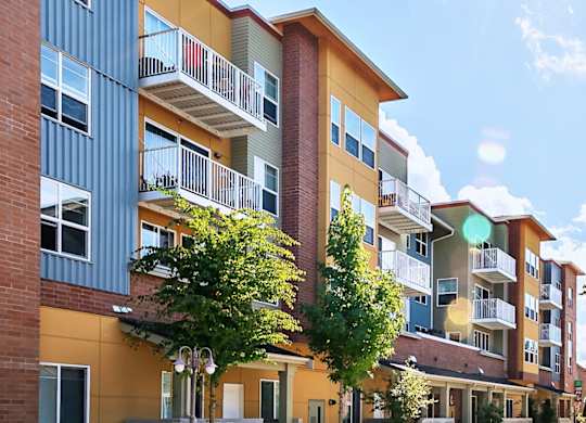 A sunny day at a modern apartment complex with a clear blue sky.