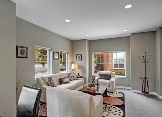 A living room with a couch, chairs, and a coffee table.