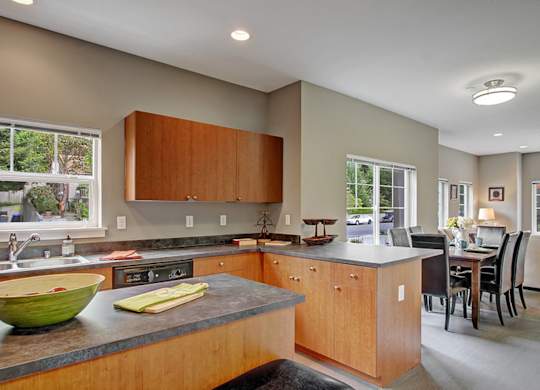 A kitchen with wooden cabinets and a green bowl on the counter.