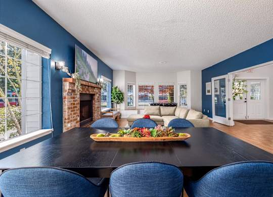 A dining room with a black table and blue chairs.