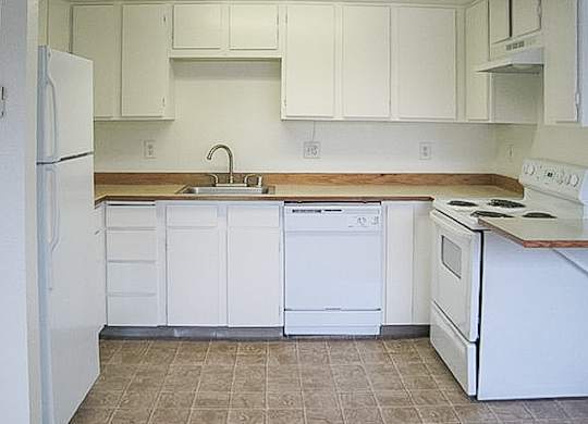A kitchen with white appliances and cabinets.