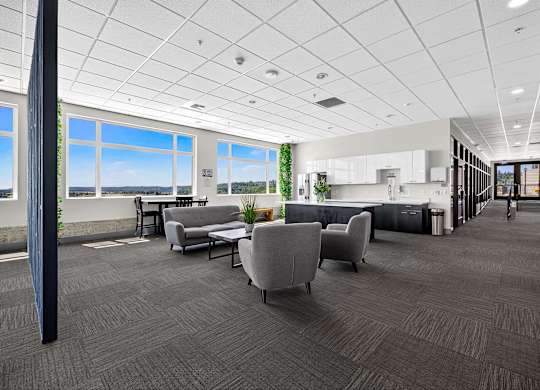 A spacious office with grey carpeting and furniture.