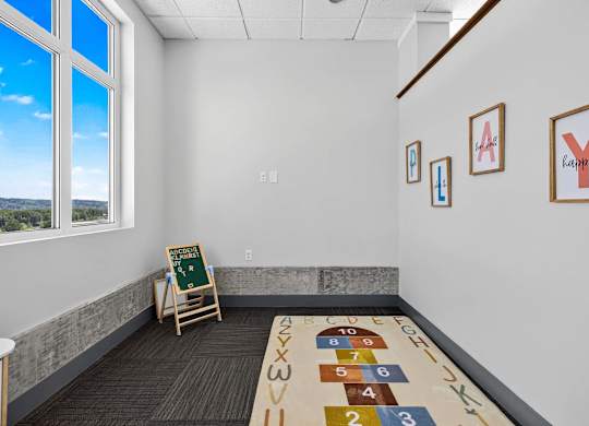 A room with a carpet and a mat on the floor with numbers and letters on it.