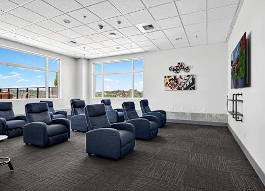 A room with blue chairs and a painting on the wall.