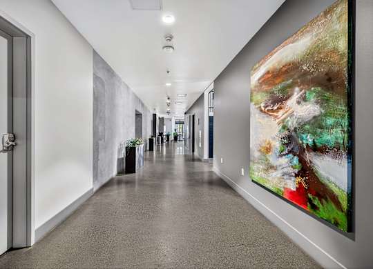 A long hallway with a painting on the wall.
