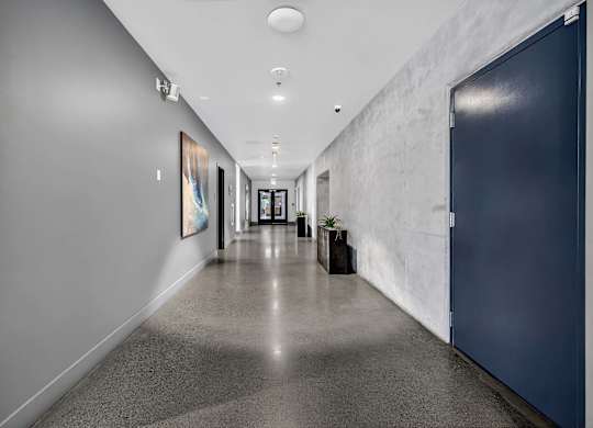 A long hallway with a blue door on the right.