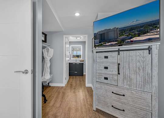 A hallway with a statue, a TV, and a trash can.