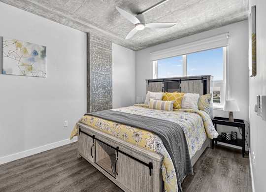 A bedroom with a large bed and a ceiling fan.
