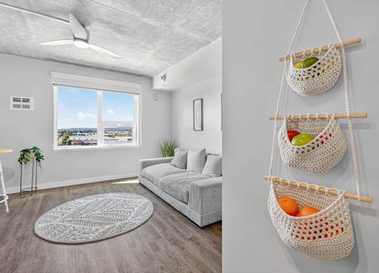A living room with a white sofa and a window with a view of the city.