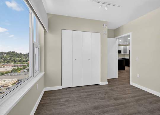 A room with a large window and a white door.