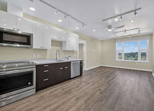 A spacious kitchen with wood flooring and stainless steel appliances.