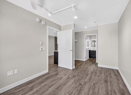 A room with a white door and a brown floor.