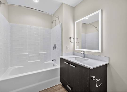 A white bathroom with a white tub and sink.