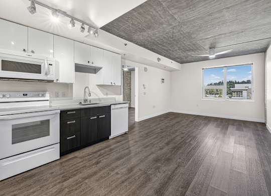 A kitchen with white appliances and wooden floors.