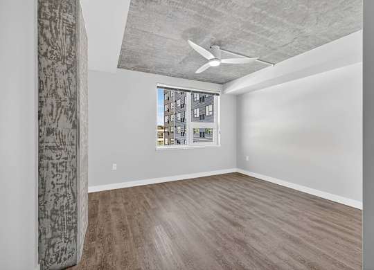 A room with a window and a ceiling fan.