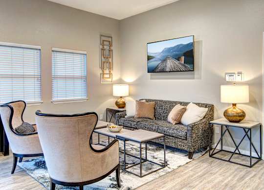 A living room with a couch, two chairs, and a coffee table.