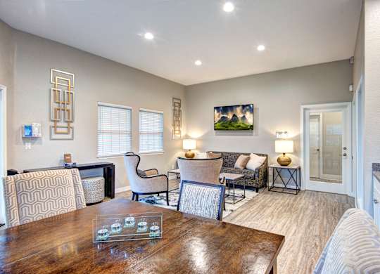 A well-lit living room with a dining table and chairs.