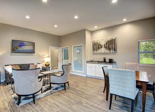 A well-lit living room with a dining area and a kitchen in the background.