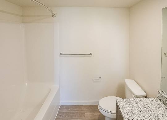 A white bathroom with a toilet, sink, and shower.
