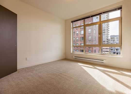A room with a large window and a carpeted floor.