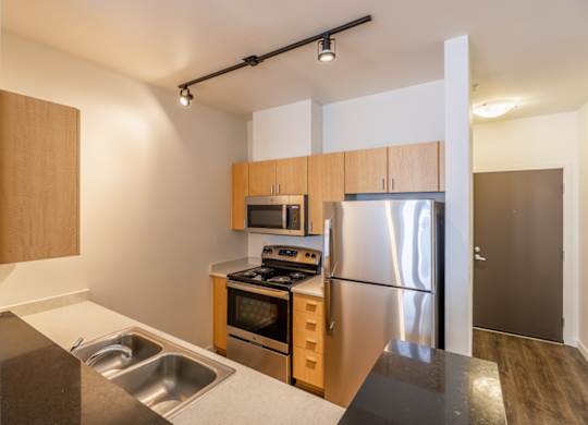 A modern kitchen with stainless steel appliances and wooden cabinets.